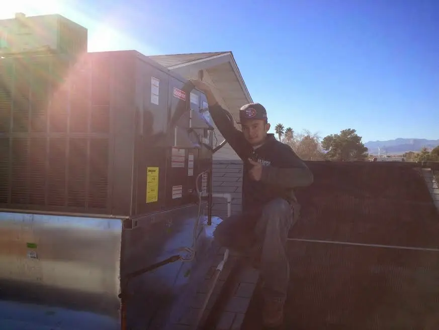 HVAC technician performing Air Duct Cleaning on a rooftop unit in Mammoth Lakes
