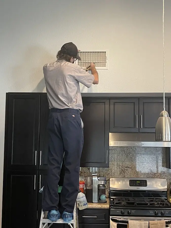 Technician inspecting an air vent during HVAC service in Mammoth Lakes